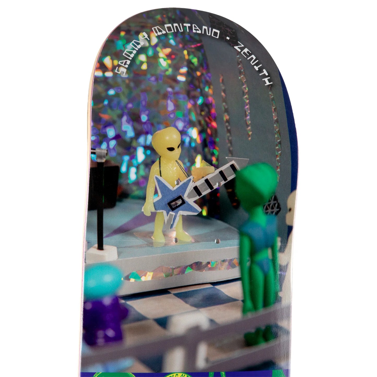 A miniature diorama miniature set featuring a yellow alien playing a blue star-shaped guitar on a stage, with other small colorful alien figures and holographic backdrop details.