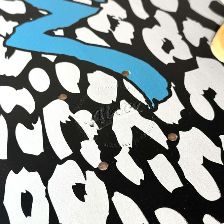 Close-up of a vinyl record with a blue 'Z' and white silhouette design on a black background.