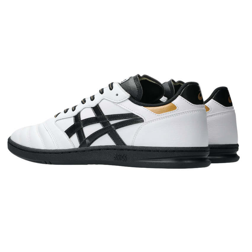 White and black sneaker with gold accents on a light gray background