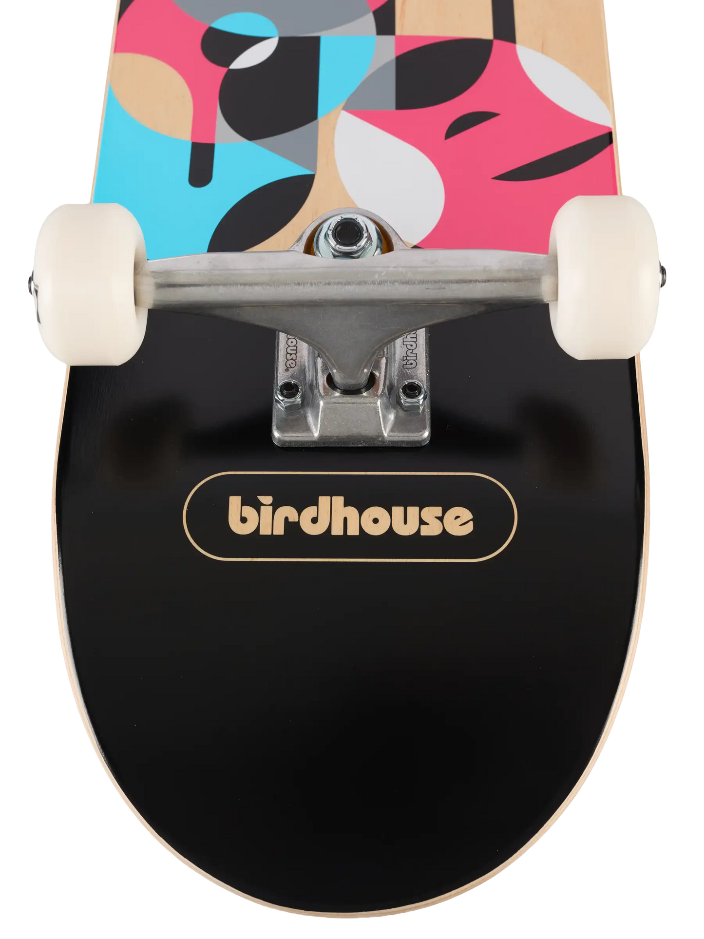 Close-up of a skateboard deck underside with a black grip tape surface, a gold birdhouse logo, and a colorful abstract pattern on the top in pink, blue, beige, black, and white. Cream-colored wheels and silver trucks are visible.