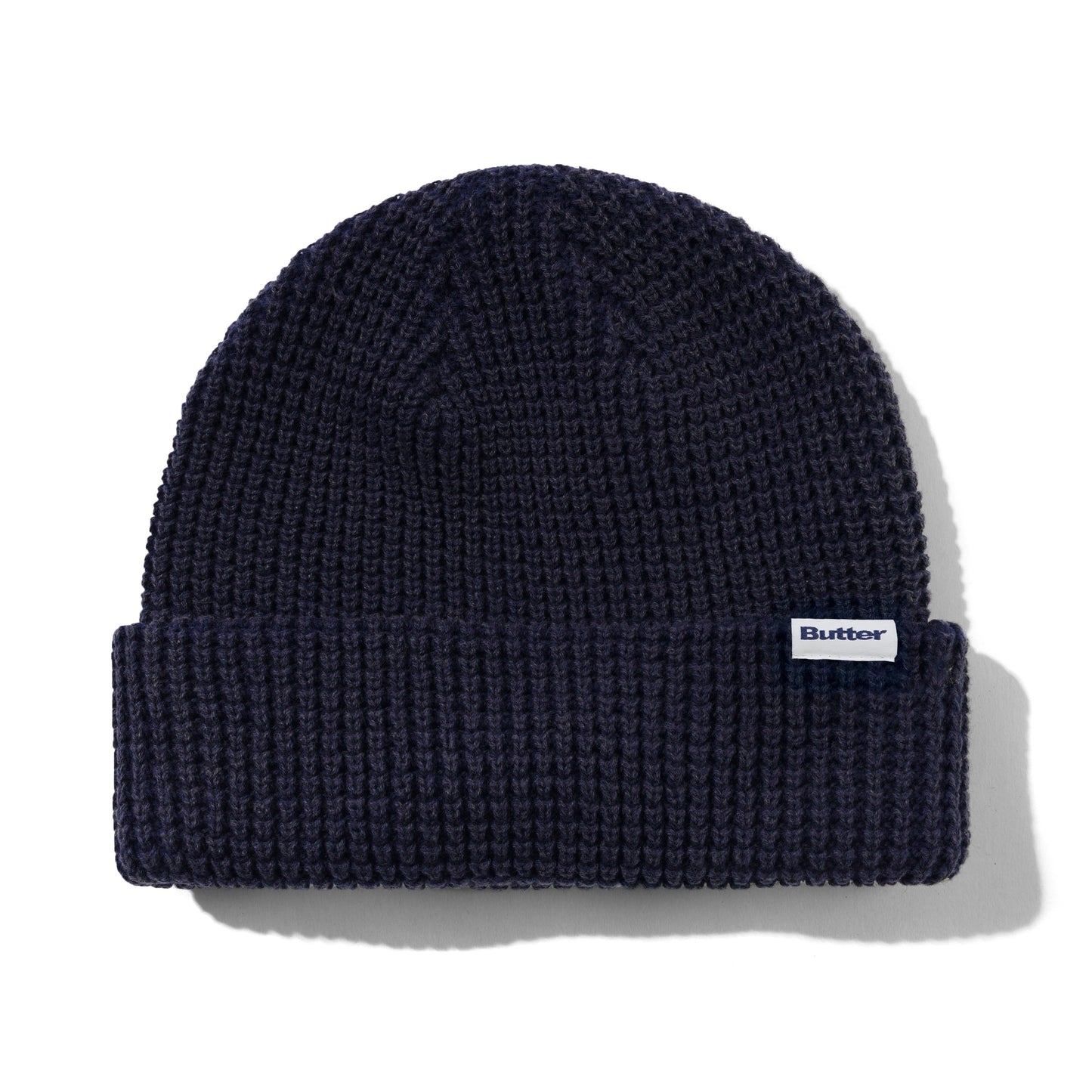 Navy blue knit beanie with a brand label on a white background