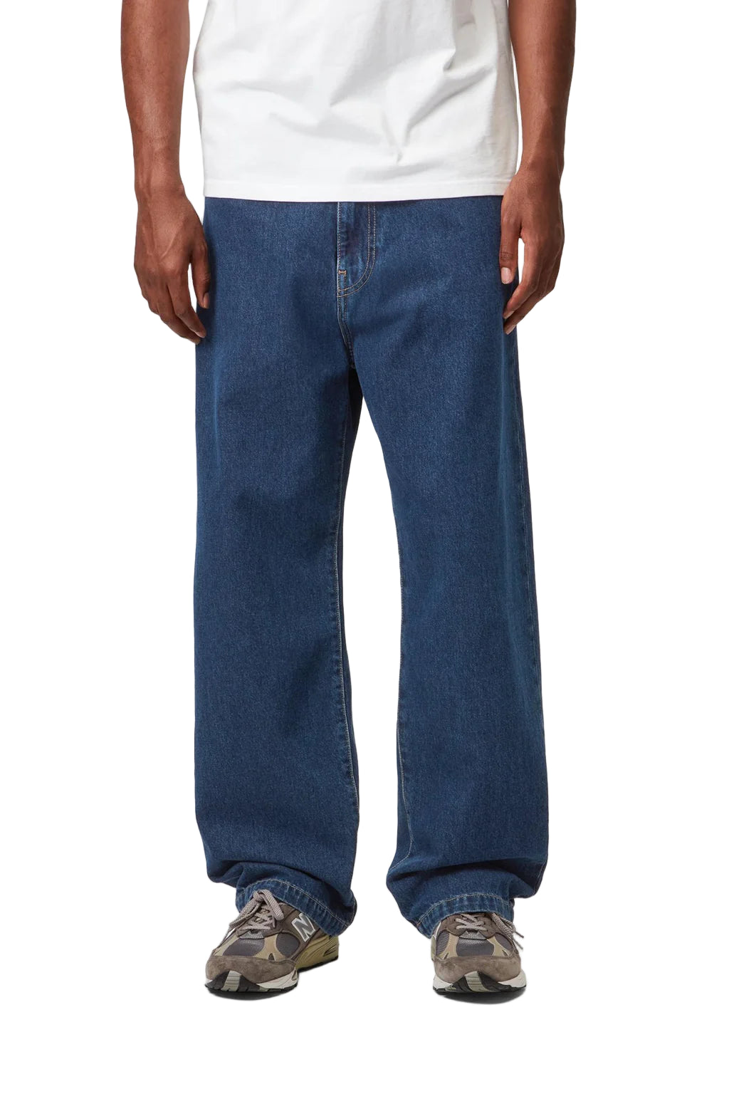 Person wearing blue jeans and a white shirt on a plain background