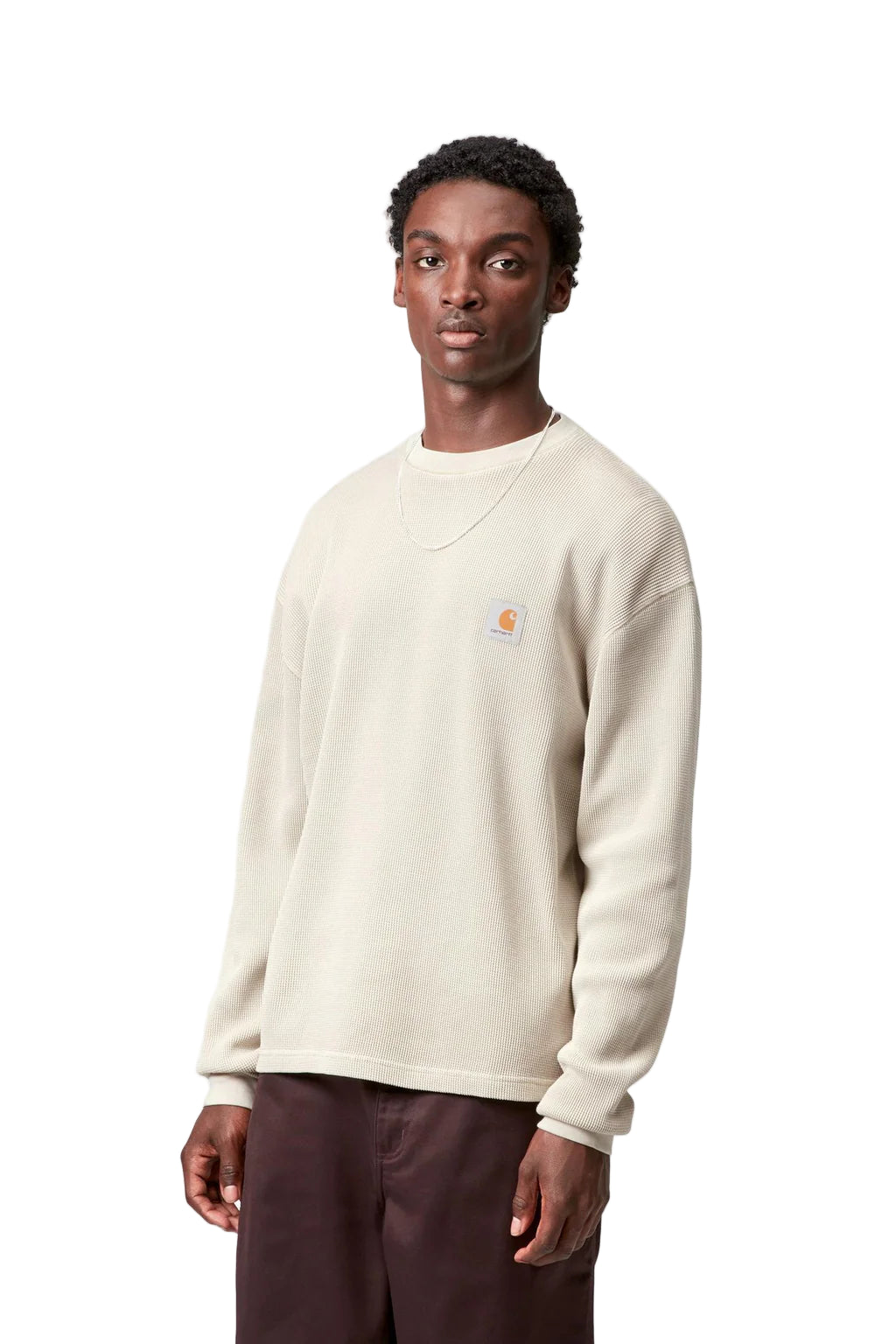 Man wearing a cream-colored sweatshirt with a brand logo on a white background