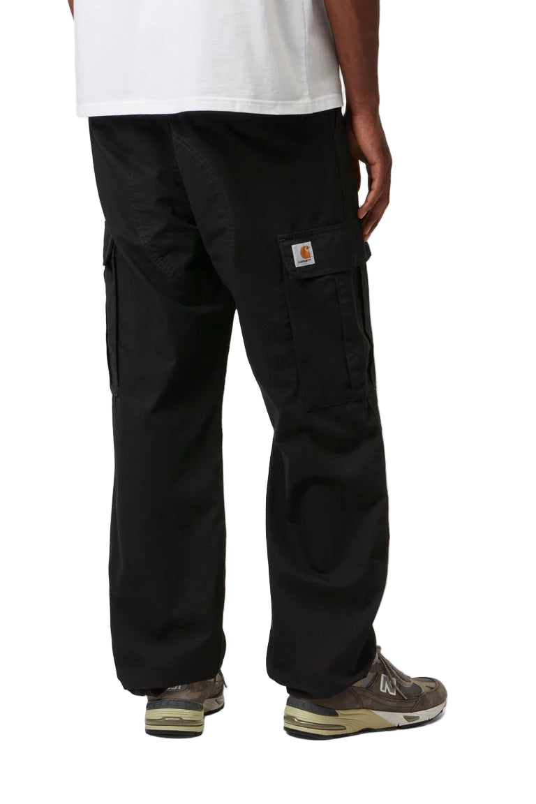 Person wearing black cargo pants with a visible brand logo on a white background