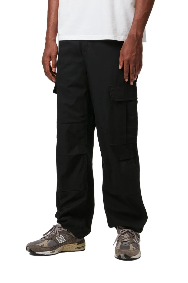 Person wearing black cargo pants on a white background