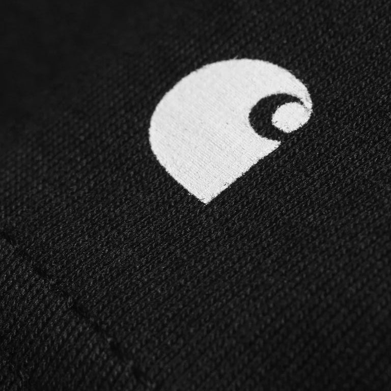 Close-up of a black fabric with a white logo on a dark background