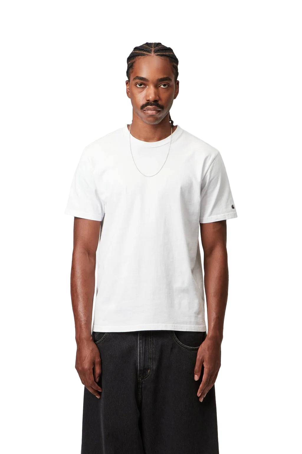 Man wearing a plain white t-shirt and dark pants on a white background