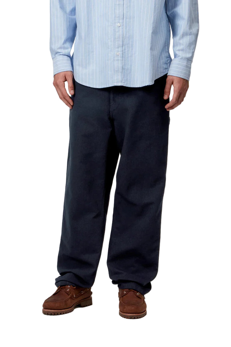 Person wearing a light blue striped shirt, dark pants, and brown shoes on a white background