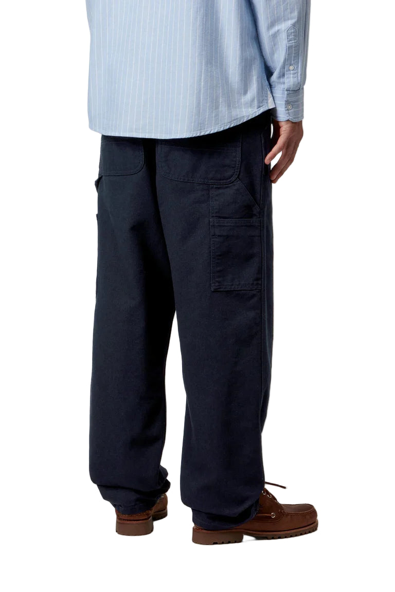 Person wearing navy cargo pants with a light blue shirt on a white background