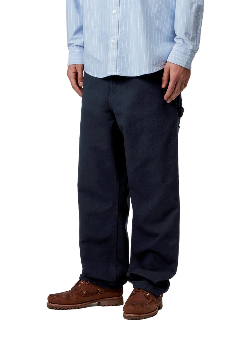 Person wearing navy pants and a light blue striped shirt on a white background