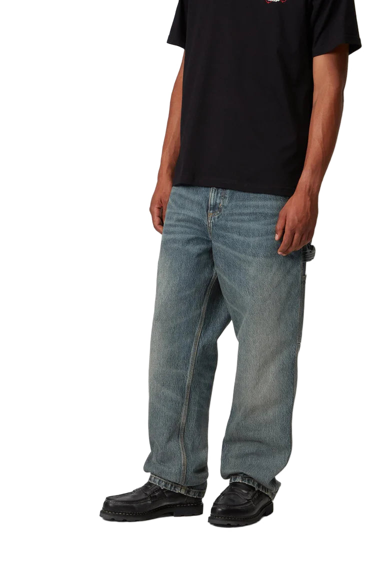 Person wearing blue jeans and black shoes on a white background