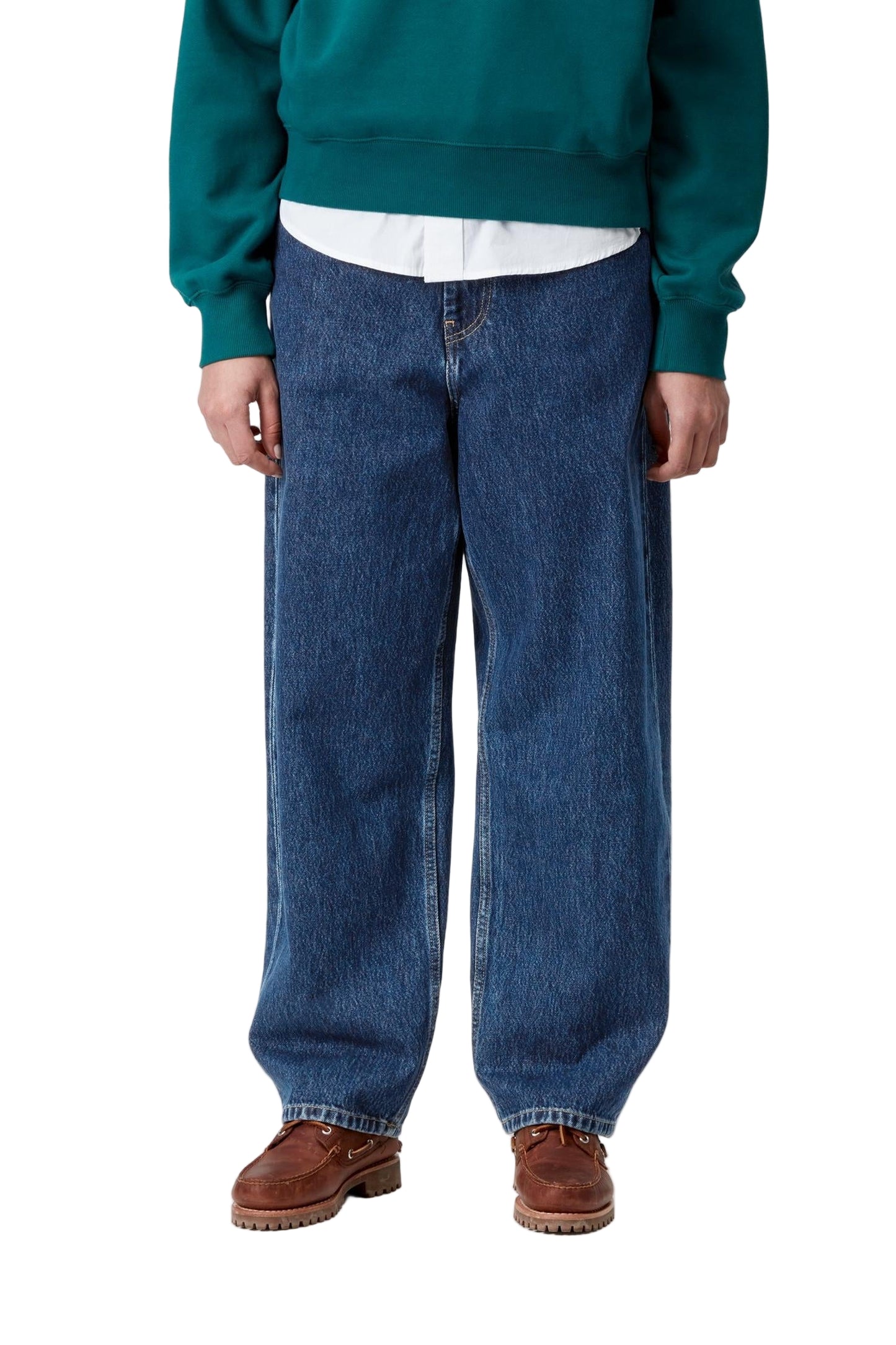 Person wearing a teal sweater, white shirt, blue jeans, and brown shoes on a white background
