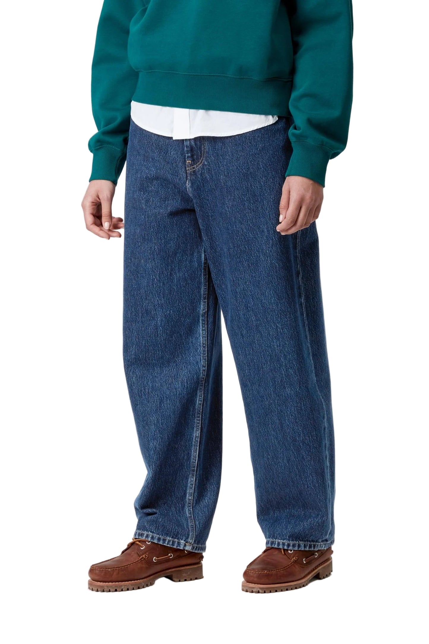 Person wearing a teal sweater, white shirt, blue jeans, and brown shoes on a white background
