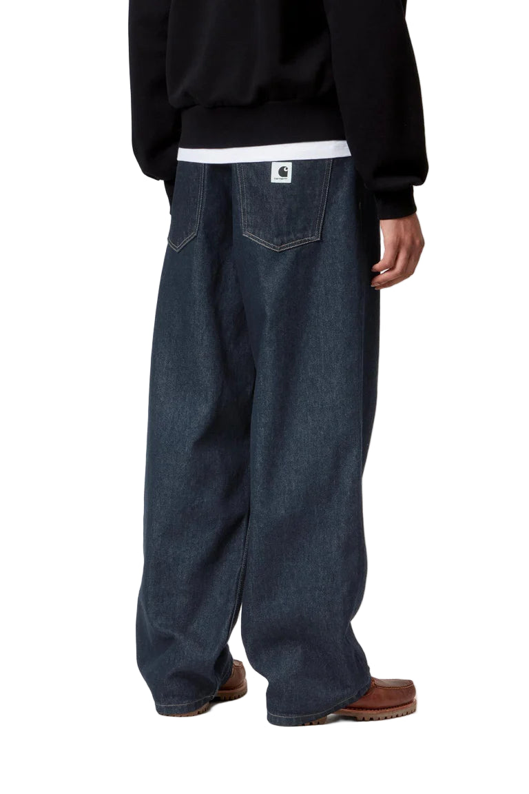 Person wearing dark blue jeans and a black sweatshirt on a white background