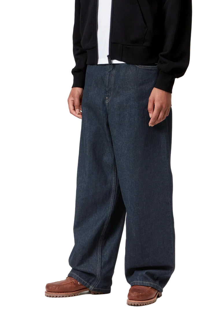 Person wearing dark blue jeans and a black jacket on a white background