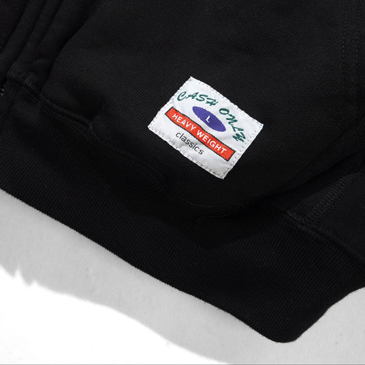 Close-up of a black jacket with a brand label on a white background