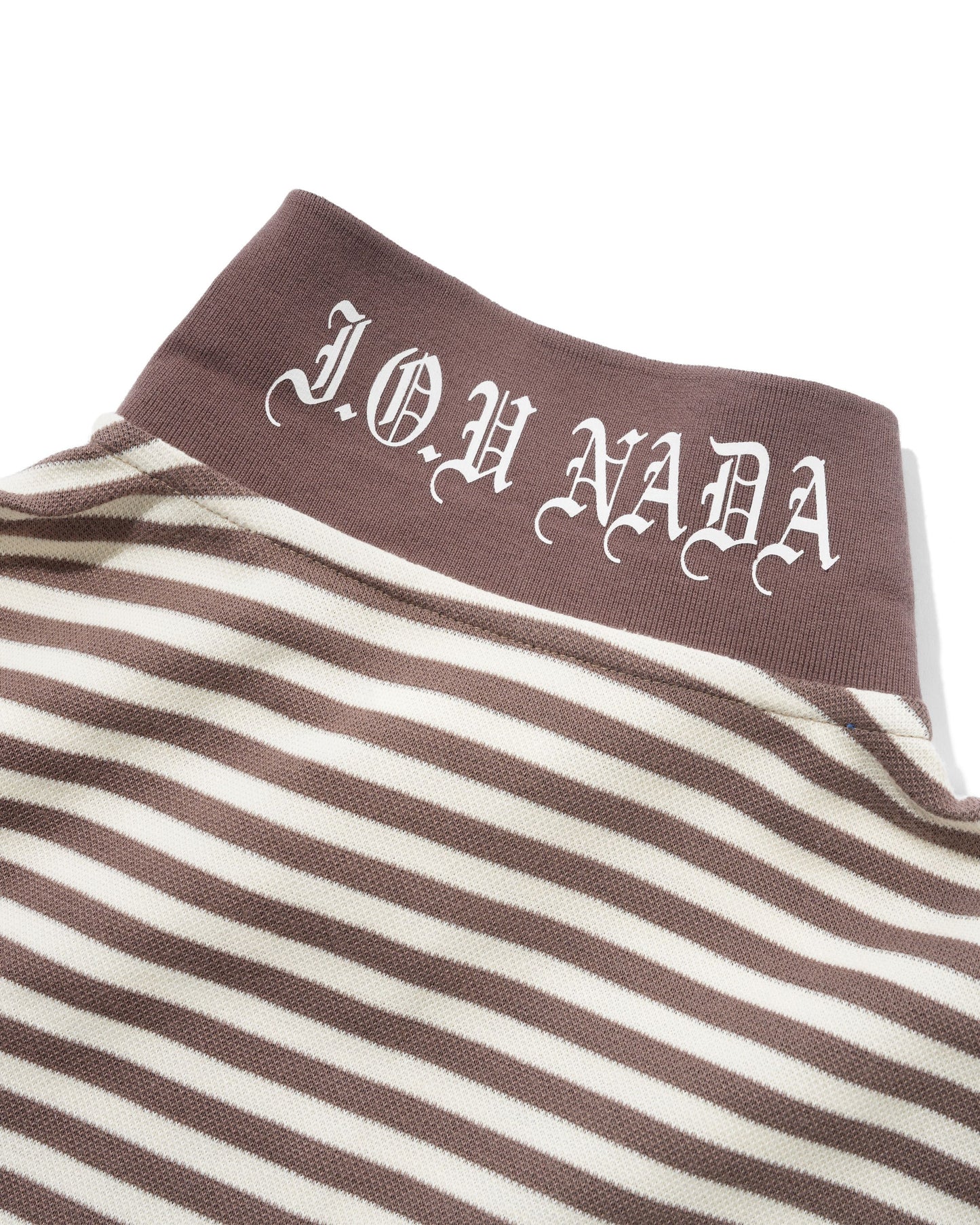 Close-up of a striped knit garment with a brown ribbed collar featuring the white Gothic-style text 'JOH NADA'.