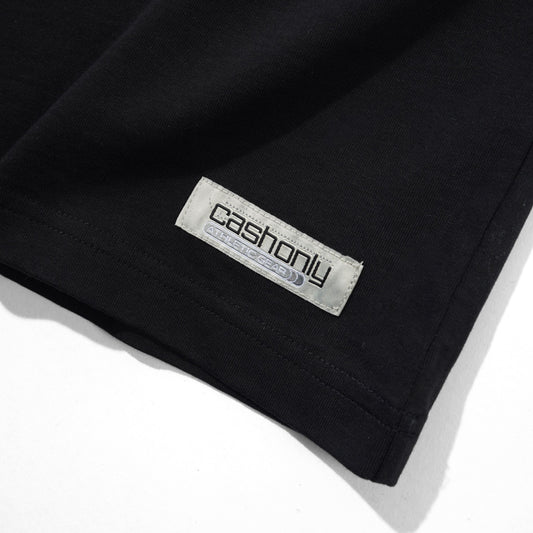 Close-up of a black garment corner with a visible rectangular brand label reading 'cashonly' on a white background.