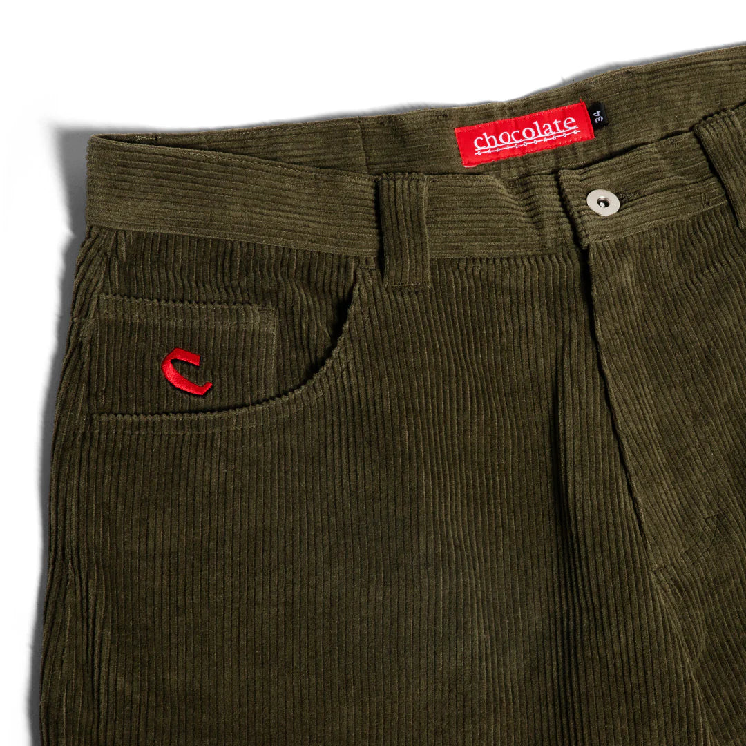 Green corduroy pants with a visible brand label on a white background