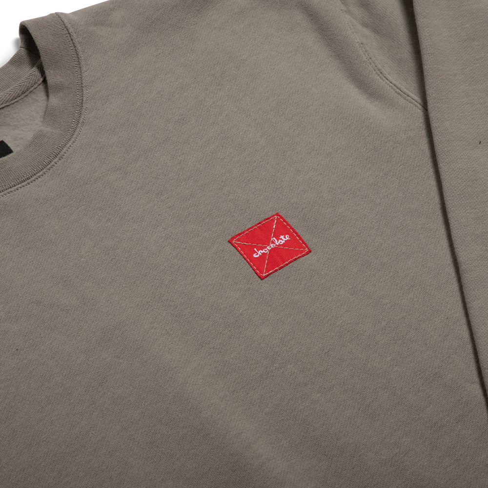 Gray sweatshirt with a red logo patch on a white background