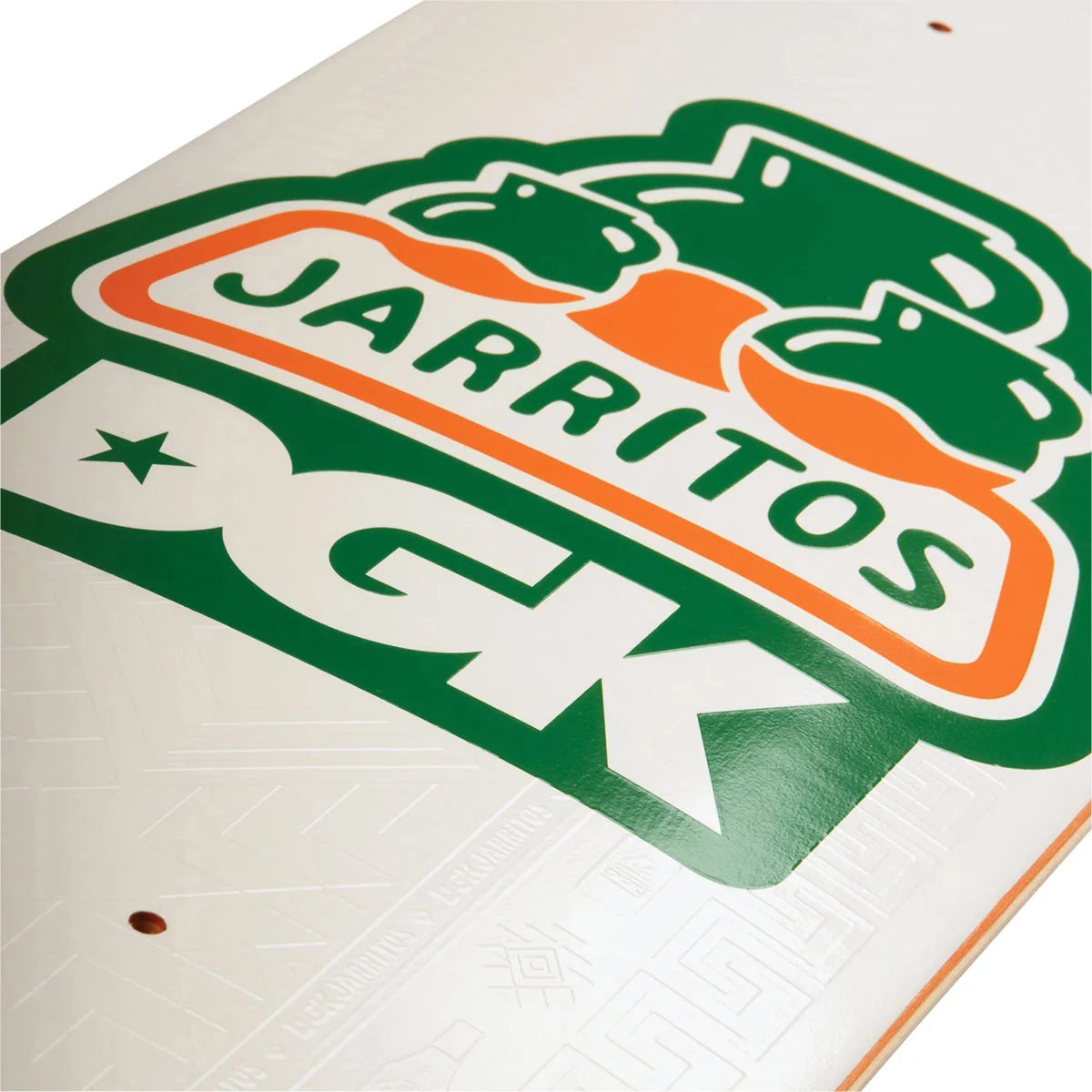 A close-up of a white surface featuring a large green and orange Jarritos DGK logo decal or printed graphic, with the word Jarritos clearly visible.