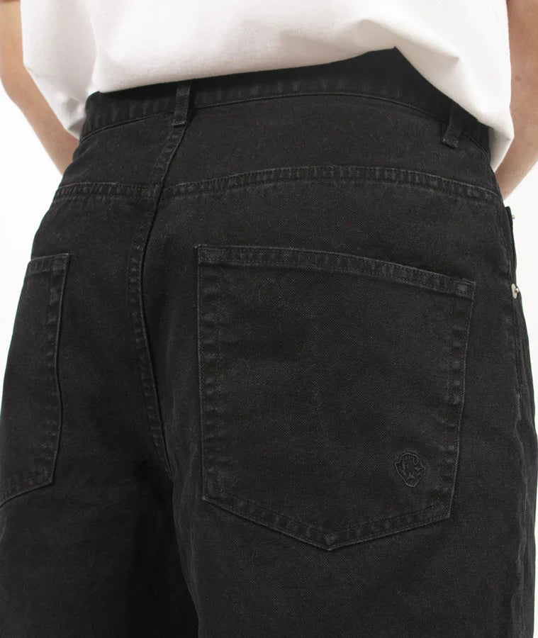 Black pants with a brand logo on the pocket worn by a person.