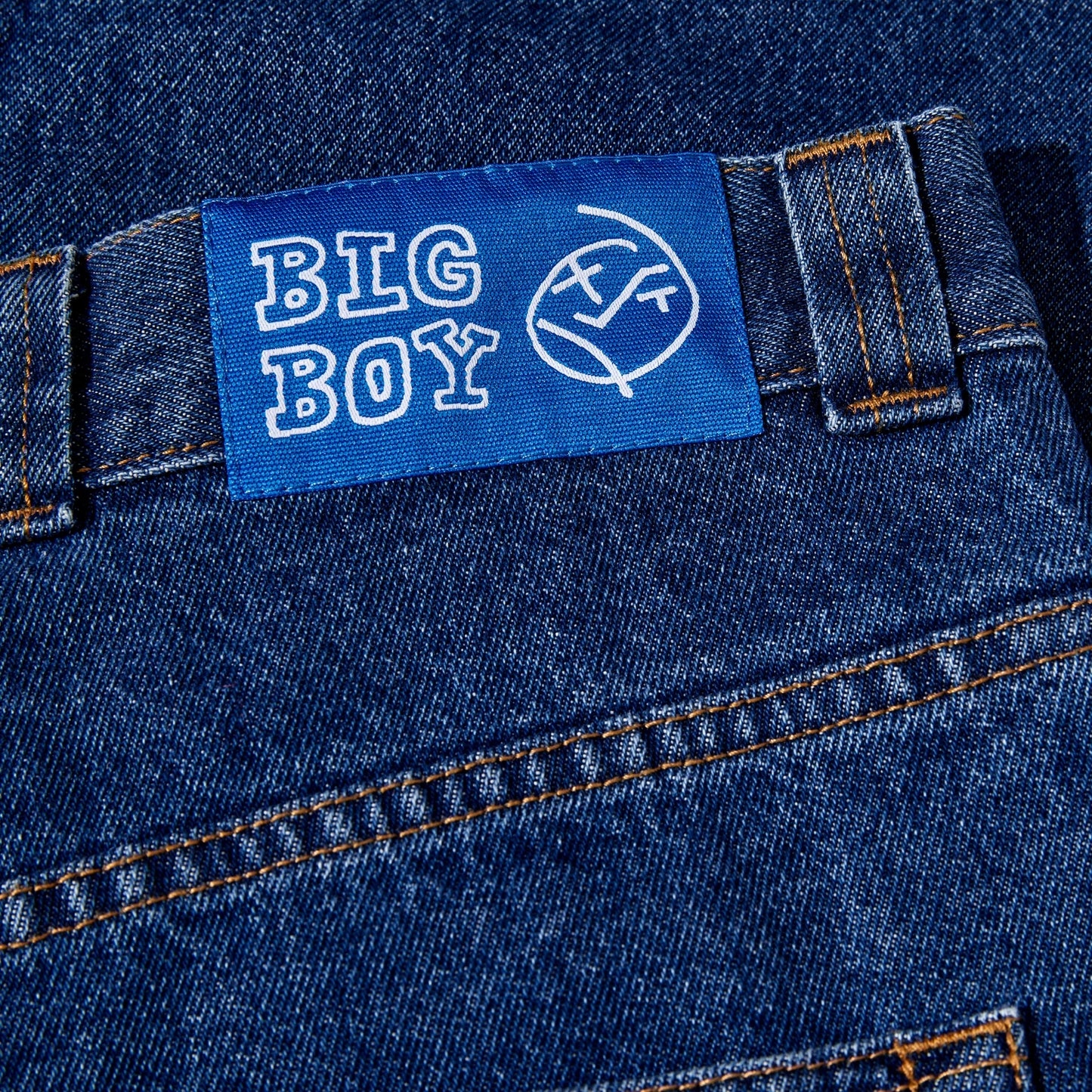 Close-up of blue denim jeans with a 'BIG BOY' label on the pocket.