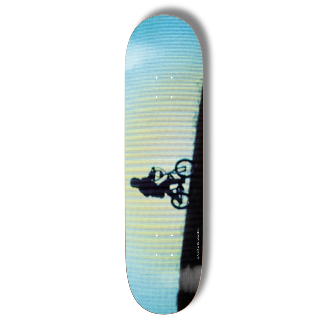 Skateboard deck with a gradient design and silhouette of a biker, on a white background