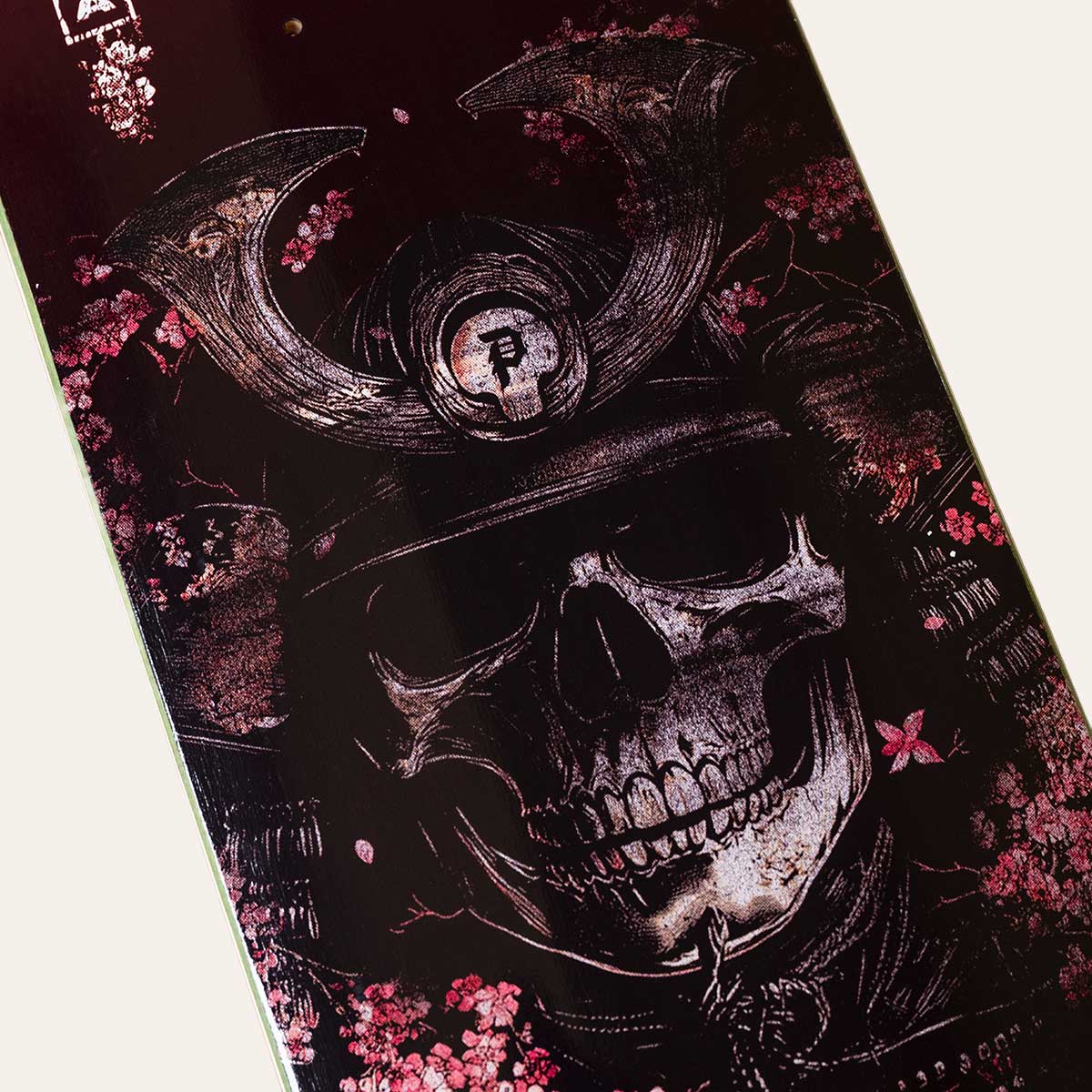 Skateboard deck with a skull and floral design on a dark background