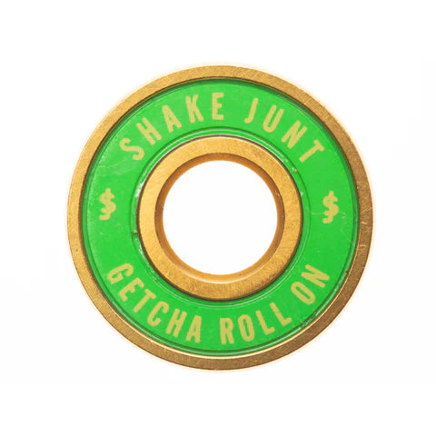 Green and gold skateboard bearing with 'Shake Junt' text on a white background