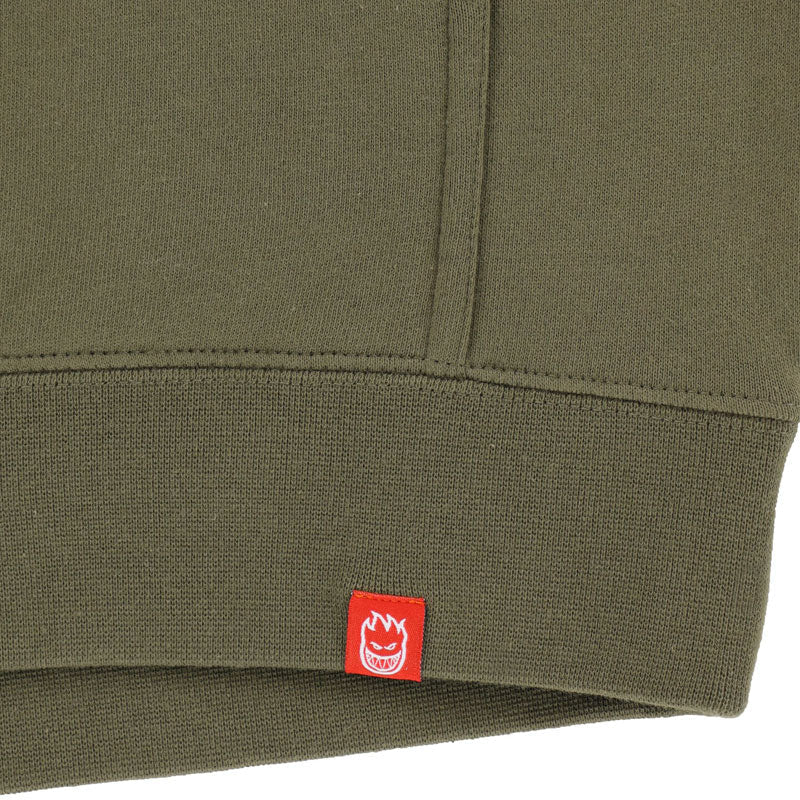 Close-up of a green fabric with a red label featuring a flame design.