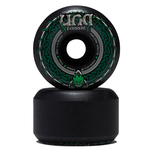 A black longboard skateboard wheel with green and silver Celtic knot graphics on top of a matching black wheel base, shown on a white background.