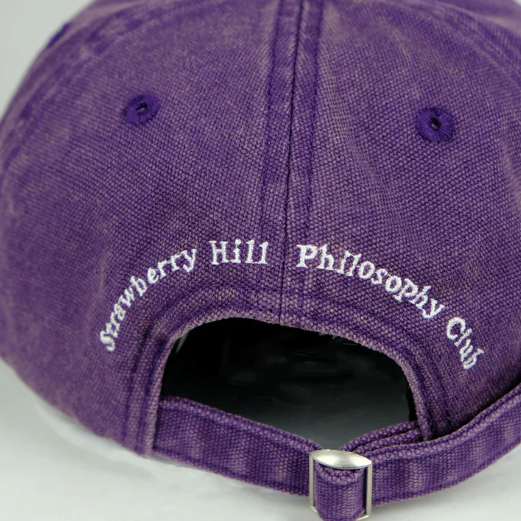 Purple cap with 'Strawberry Hill Philosophy Club' text on a white background