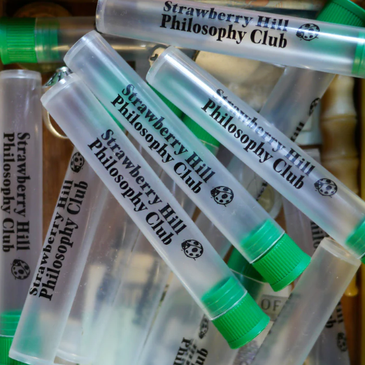Multiple 'Strawberry Hill Philosophy Club' test tube-like containers with green caps.