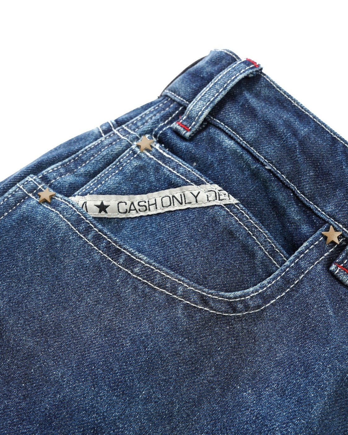 Close-up of blue denim jeans with a 'Cash Only' label on a white background