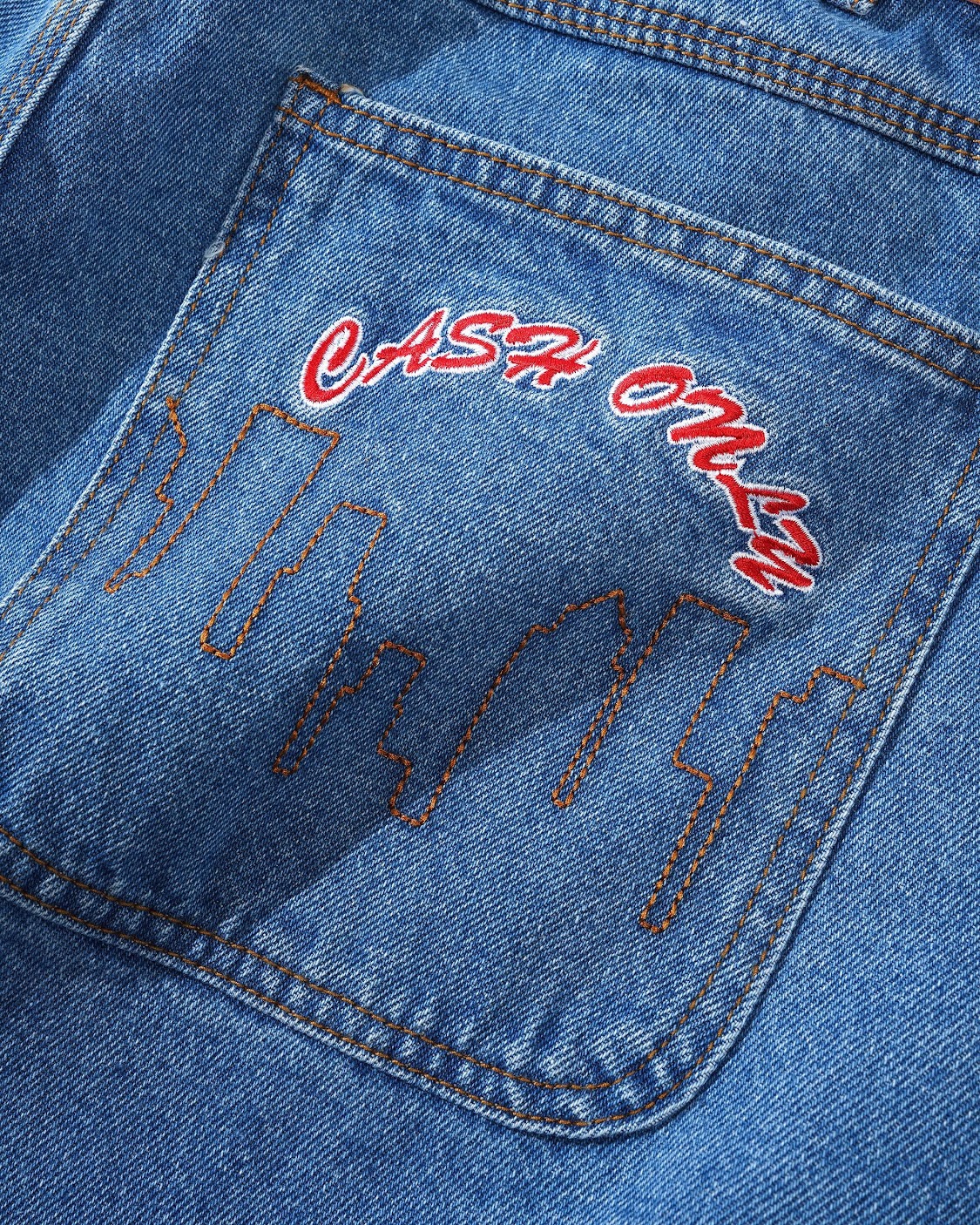 Close-up of a blue denim pocket with red and white text on a blue background