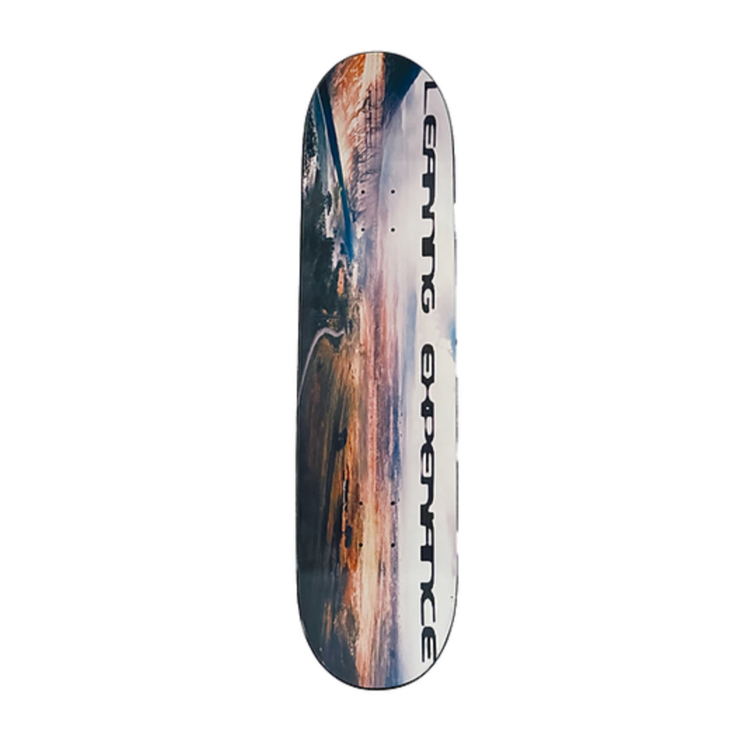 Skateboard deck with a mountain graphic and brand name on a white background