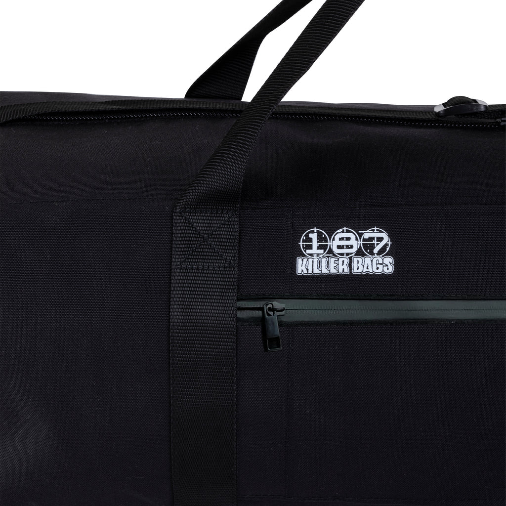 Close-up of a black fabric bag with a top zipper, webbing handle, and a white embroidered 'Killer Bags' logo patch on the front.