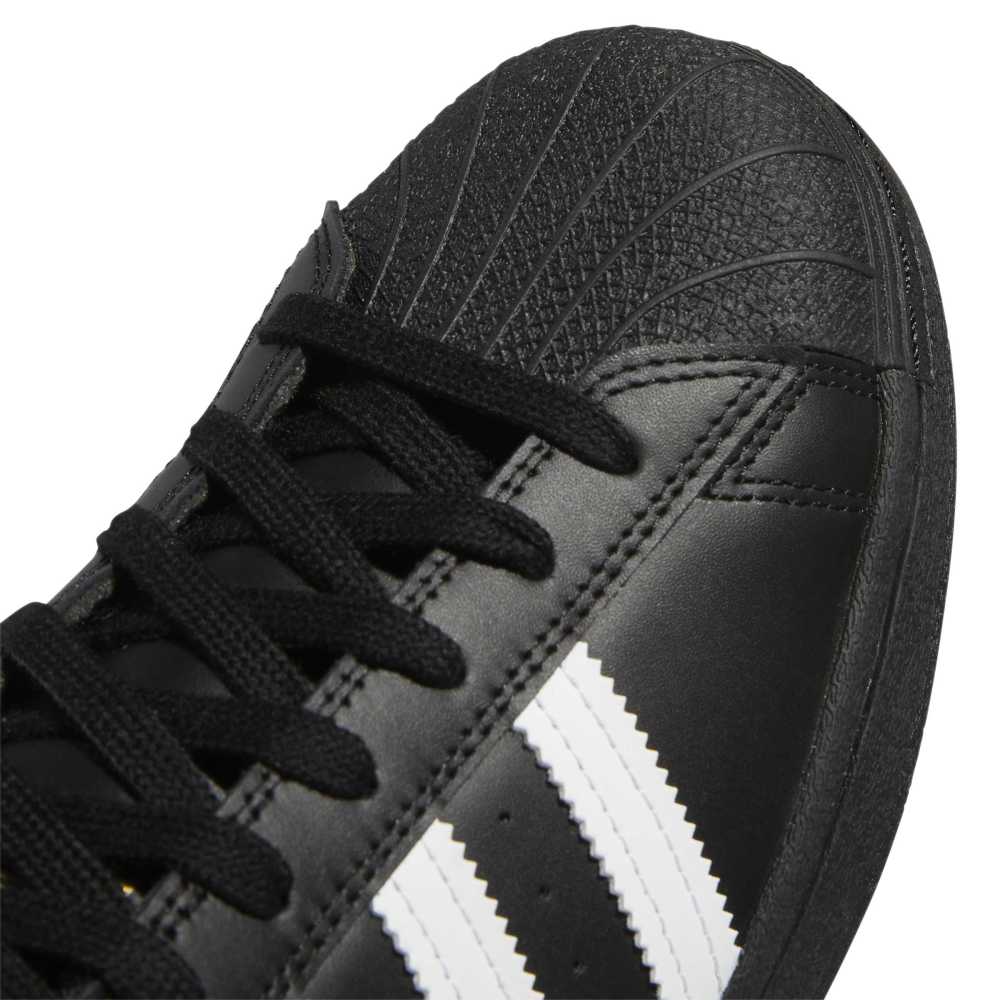 Black Adidas sneaker with white stripes on a white background