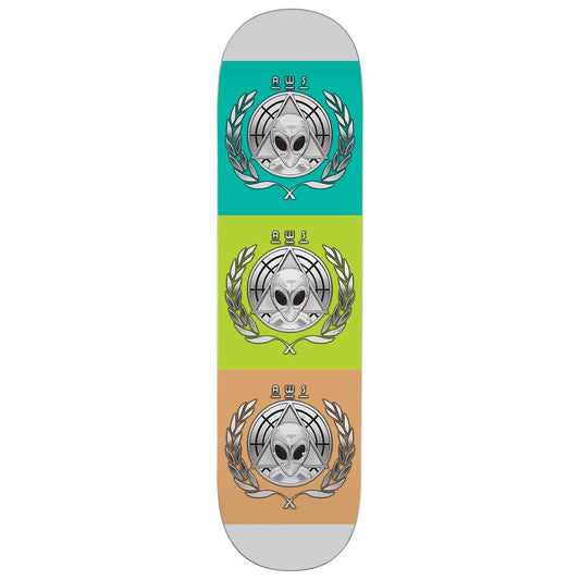 A skateboard deck shown vertically against a white background, featuring three stacked color panels in teal, lime green, and peach, each with a silver alien head and laurel wreath graphic.