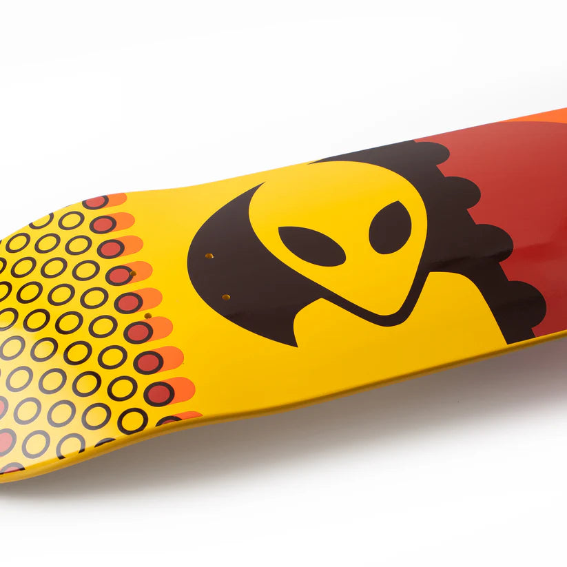 Skateboard deck with a yellow and red design featuring an alien face on a white background