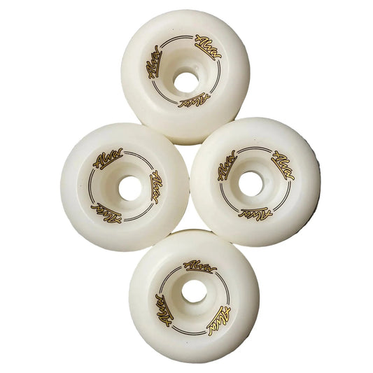 Four white roller skate wheels with gold accents on a gray surface