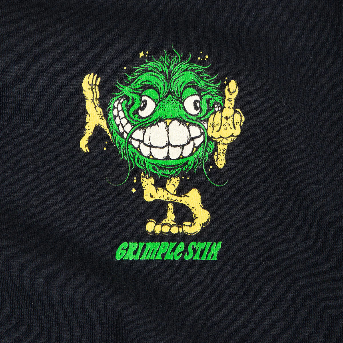 Black t-shirt with a green and yellow cartoon character and 'Grimple Stik' text on a black background