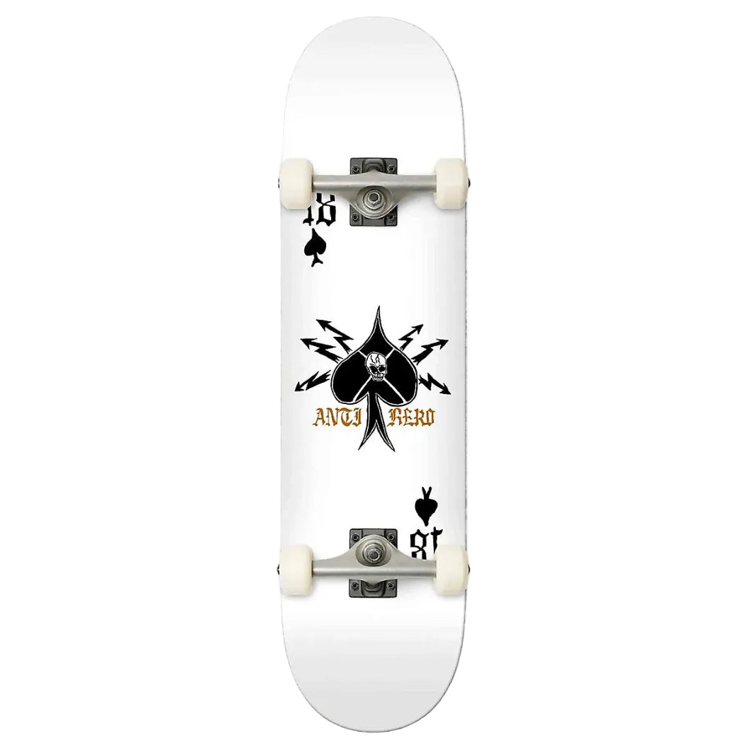 A white skateboard deck featuring a black spade graphic with a skull and crossed arrows, the text 'anti HERO' in gold, and black playing card suit symbols near the corners. The deck is shown from a top-down view with white wheels and silver trucks against a light gray background.