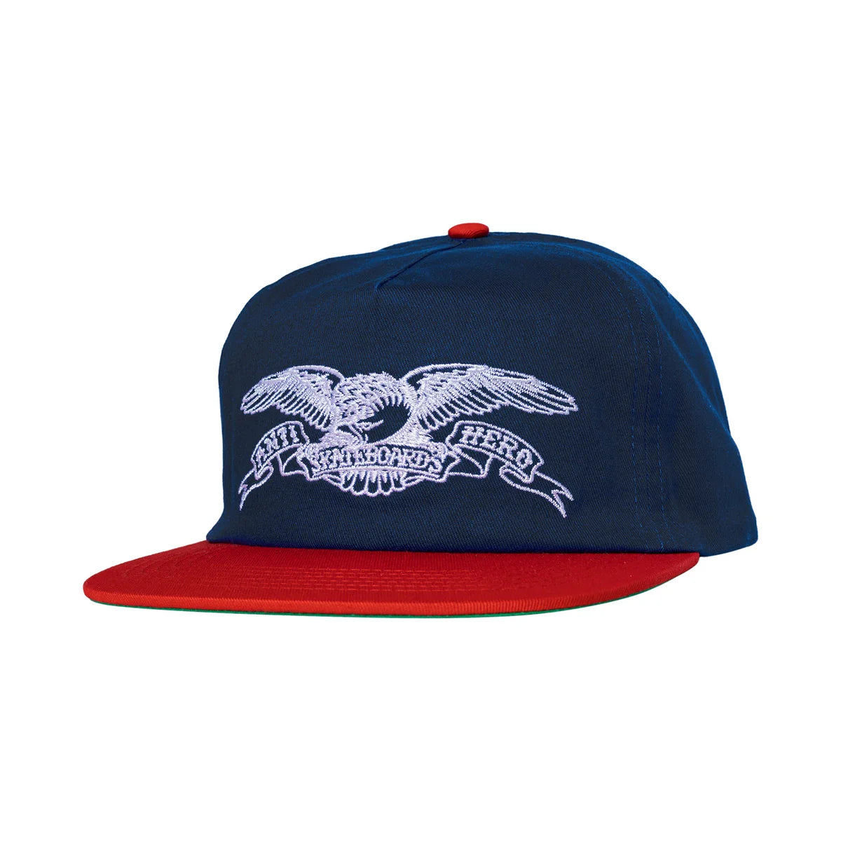 A navy blue flat-brim cap with a red brim and a red top button, featuring a white embroidered eagle and banner graphic on the front.
