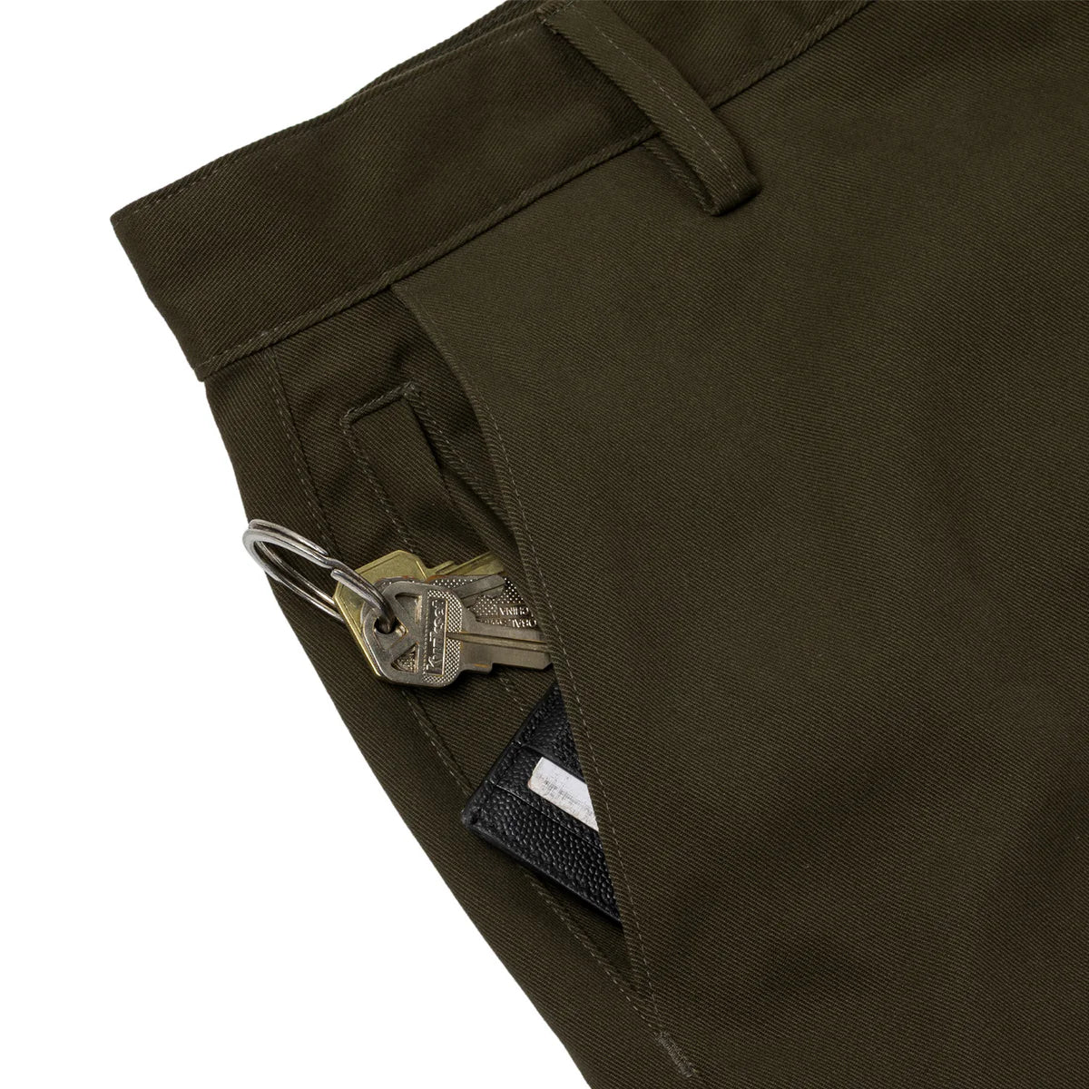 dark green shorts with a key and wallet in the pocket on a white background