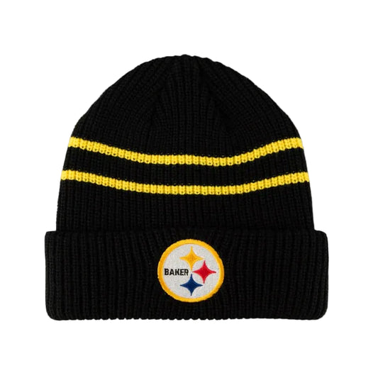 A black ribbed knit beanie hat featuring two horizontal yellow stripes on the upper portion and a circular Pittsburgh Steelers logo patch on the front cuff.