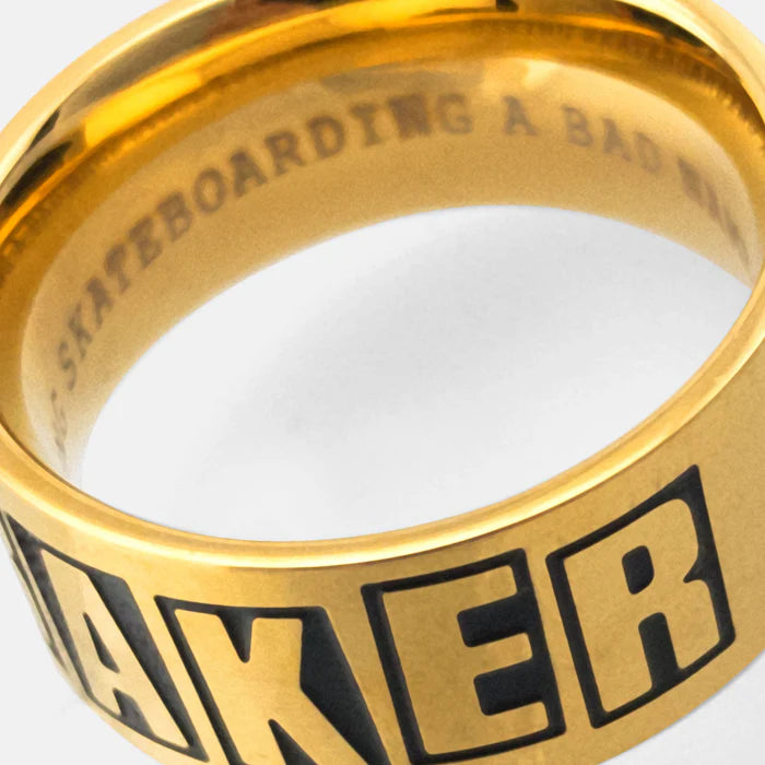 Gold ring with 'Baker' branding on a white background