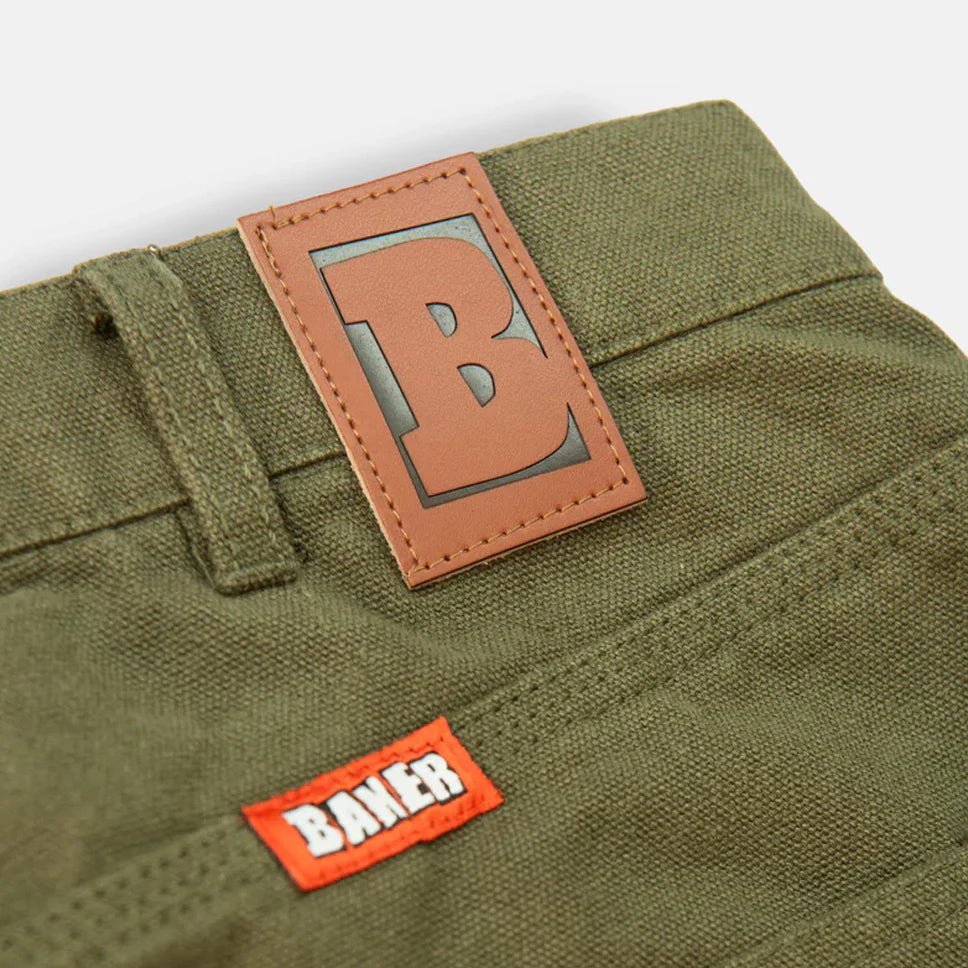 Close-up of green pants with a brown and orange label on a white background