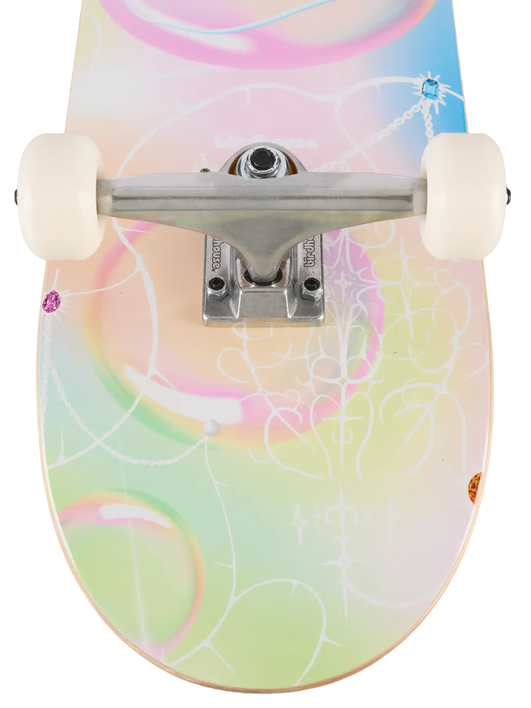 A close-up of a skateboard deck with a pastel multicolor design featuring pink, green, yellow, and blue swirls, white line art, and a silver truck with cream-colored wheels.